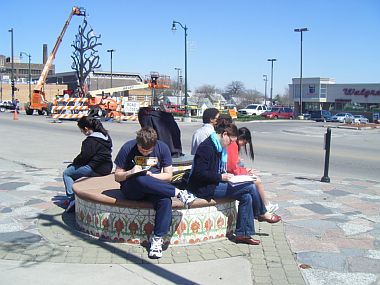 Students writing in Omaha outdoor plaza