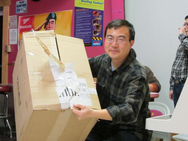 Ming Guo received a computer printer from Secret Santa at the Holiday Bowling Party. 