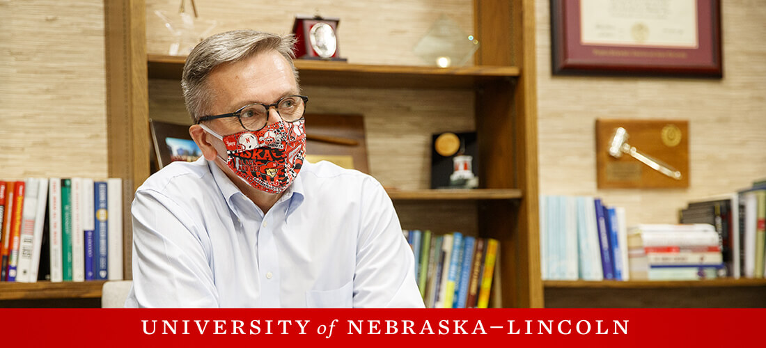 Chancellor Green with mask on, sitting at desk.