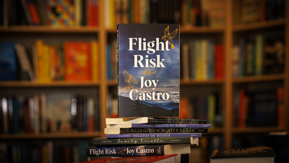 A copy of FLIGHT RISK in front of book shelves; links to news story