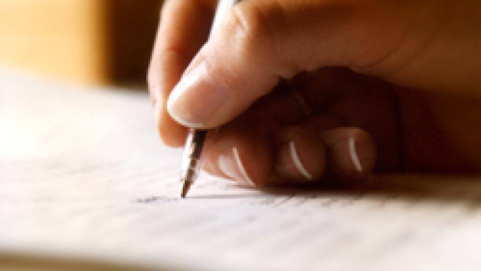 Close-up of a student writing with pencil; links to news story