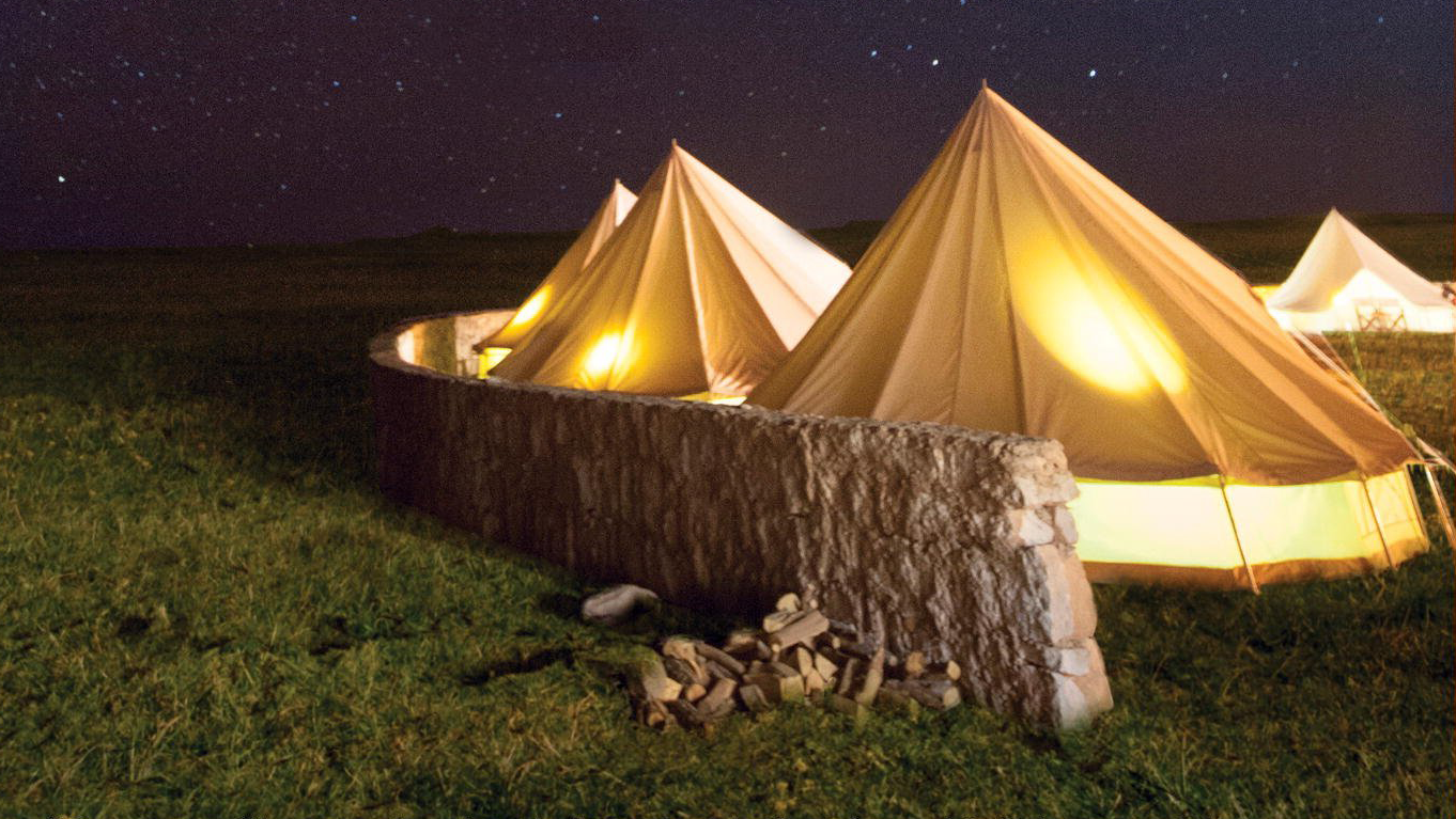 Photo of round canvas tents from the cover of Station Eleven; links to news story