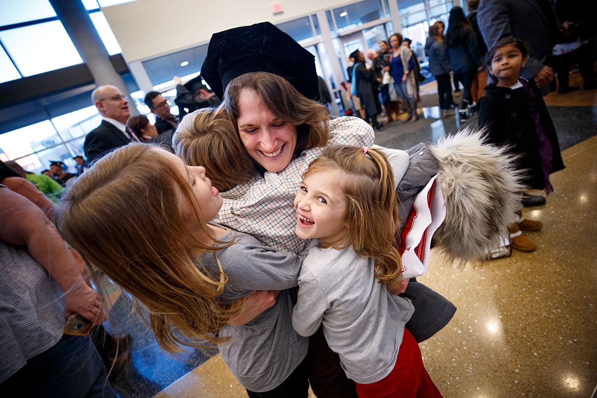 Janel Simons hugs her son and nieces after receiving her doctoral in English degree at the December 2018 Graduate Commencement and Hooding ceremony