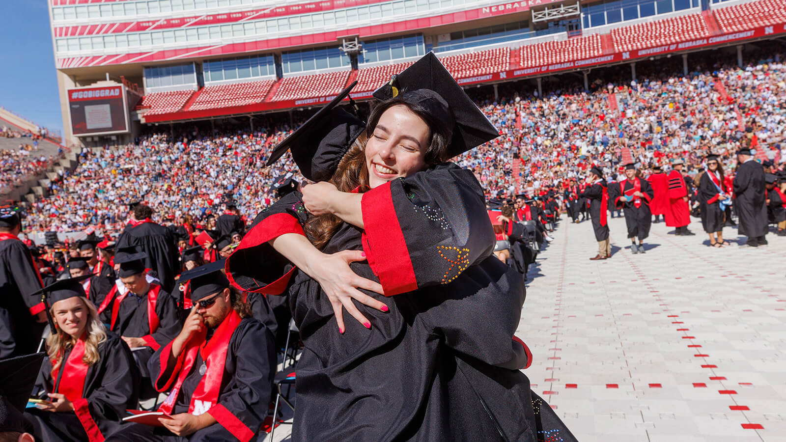Students hugging each other at ceremony in Memorial Stadium