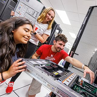 Three Husker Engineering students replace hard drives in a server at the School of Computing.