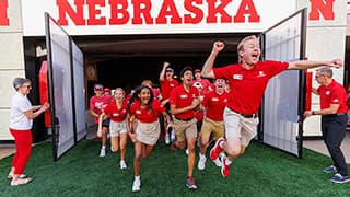N S E Orientation Leader Jackson Anderson leads new students out of the Tunnel Gates at the Tunnel Walk and New Student Welcome in Memorial Stadium.