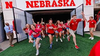 Husker students from the Class of 2027 run onto the field during the Tunnel Walk in Memorial Stadium.