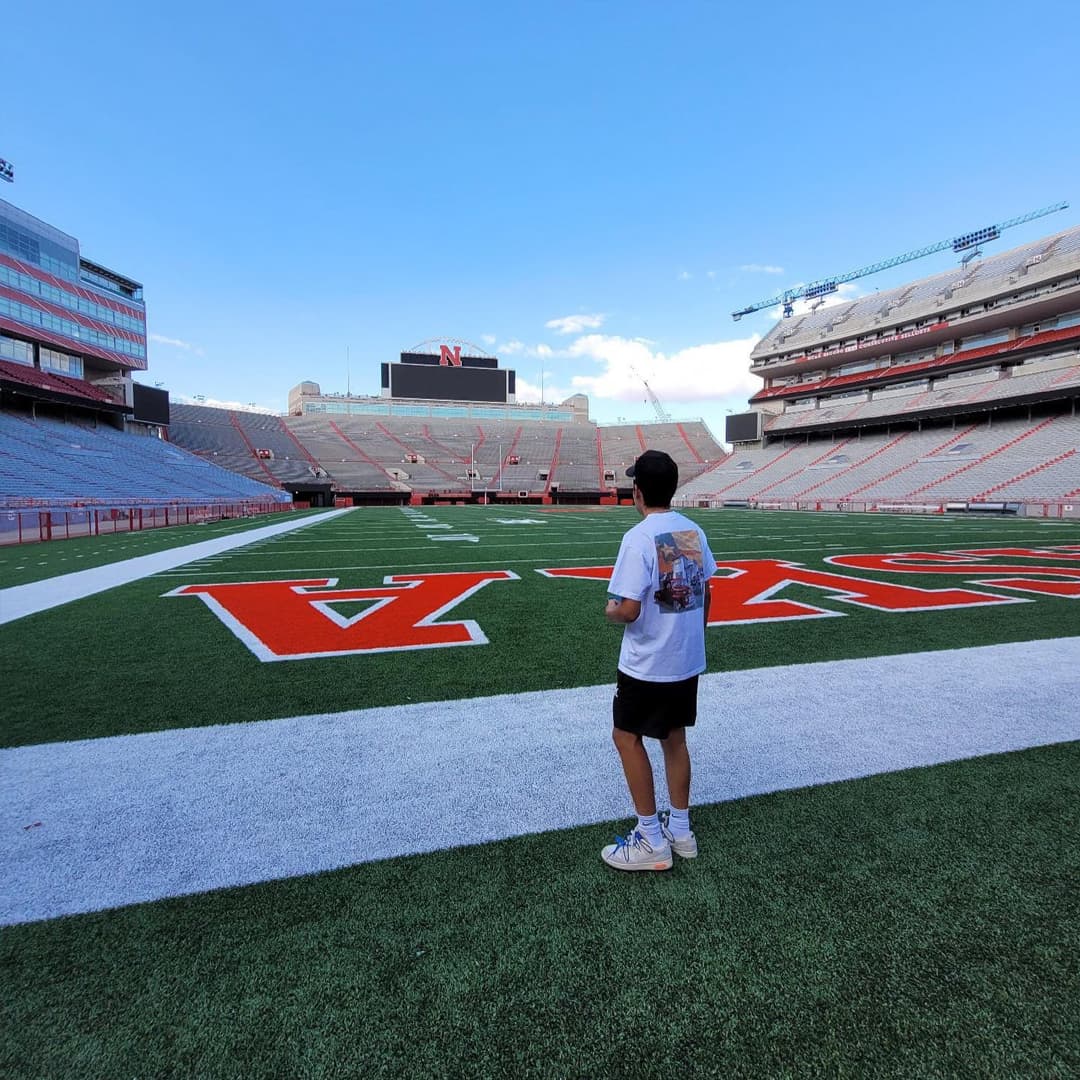 A student stands on the field inside an empty Memorial Stadium.