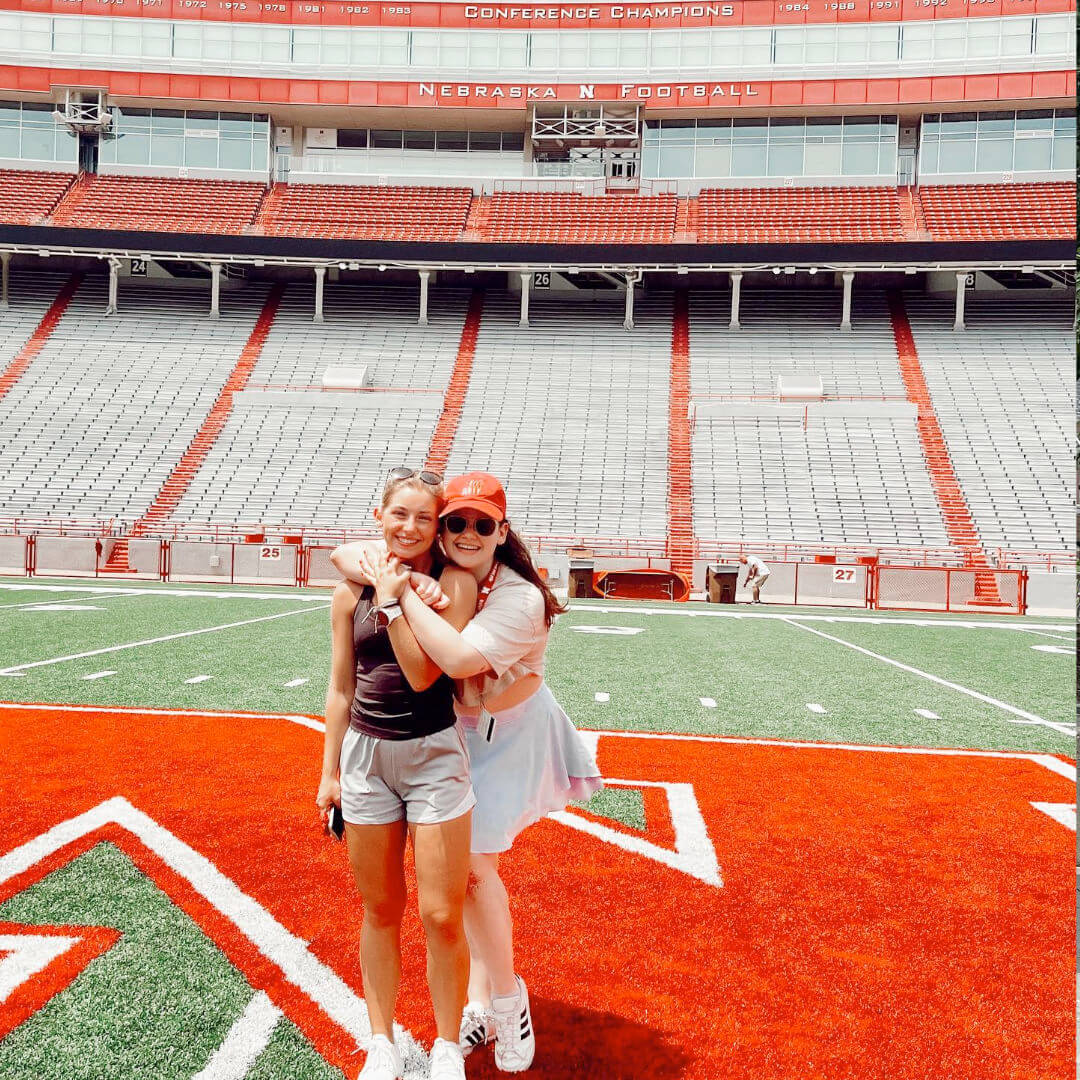 Students hugging while standing on the field at Memorial Stadium.