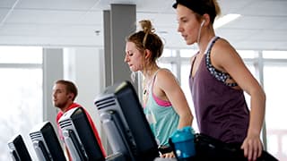 Three students use the step machines at East Campus Recreation Center.