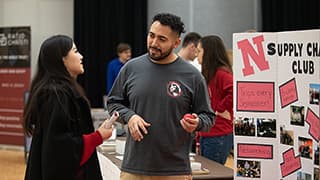 A student discusses a club with a representative of a Recognized Student Organization at the Club Fair.