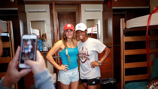 Two Nebraska students pose for a photo in their dorm.