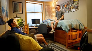 Two students hang out in a Kauffman Academic Residential Center dorm room.