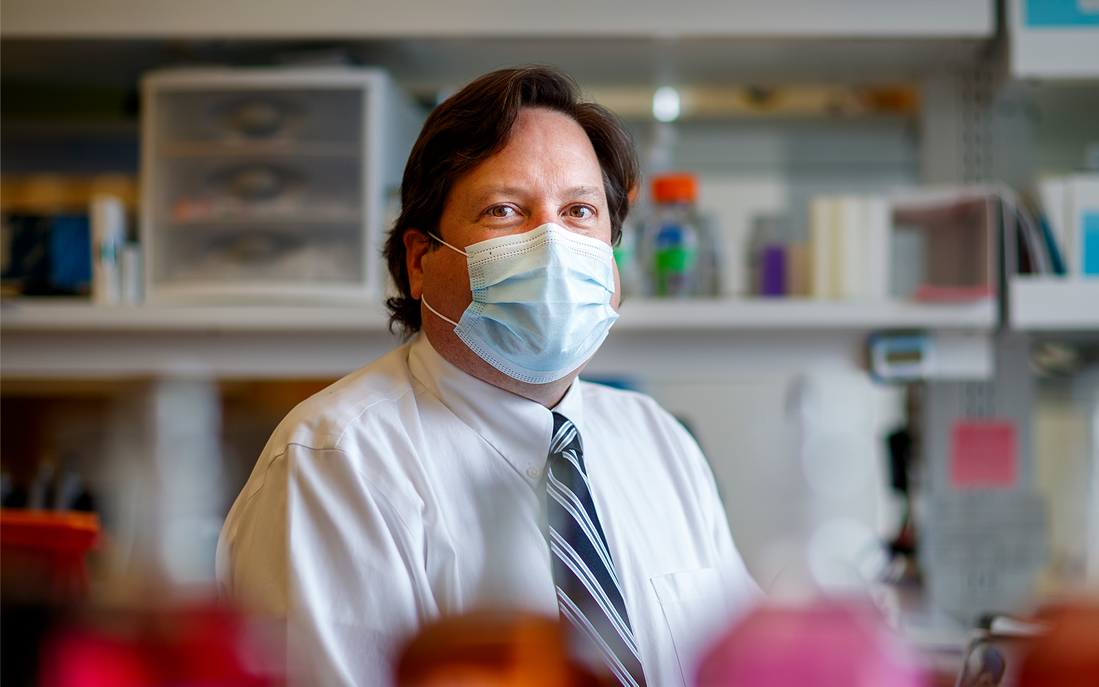 Eric Weaver sits in his lab wearing a mask
