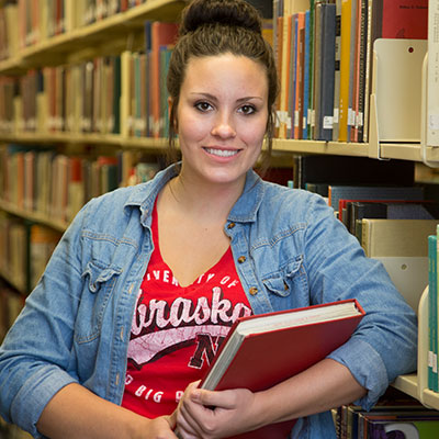 girl in library holding book