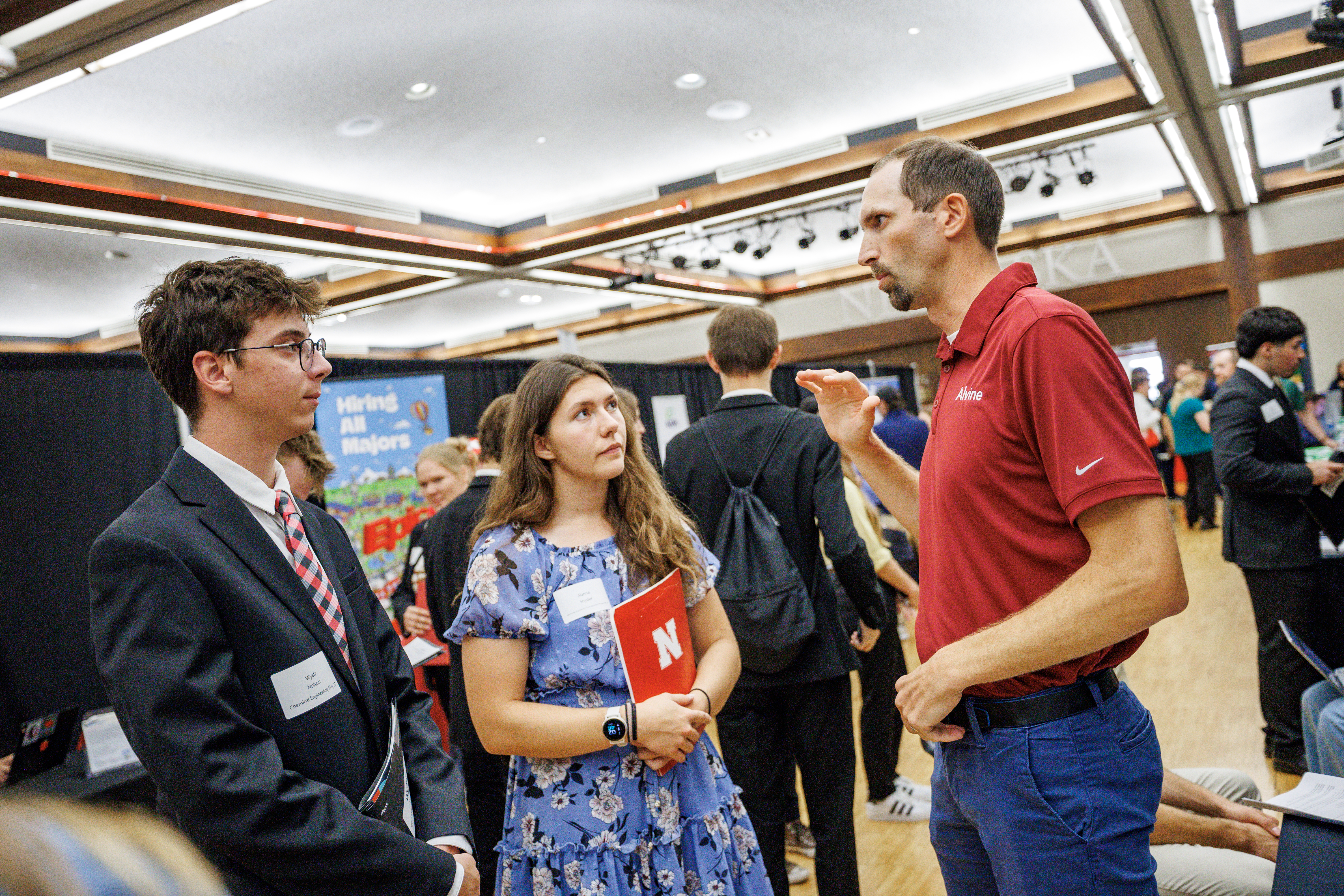Two students stand with a career professional during the 2025 Career Fair in the Nebraska Union.