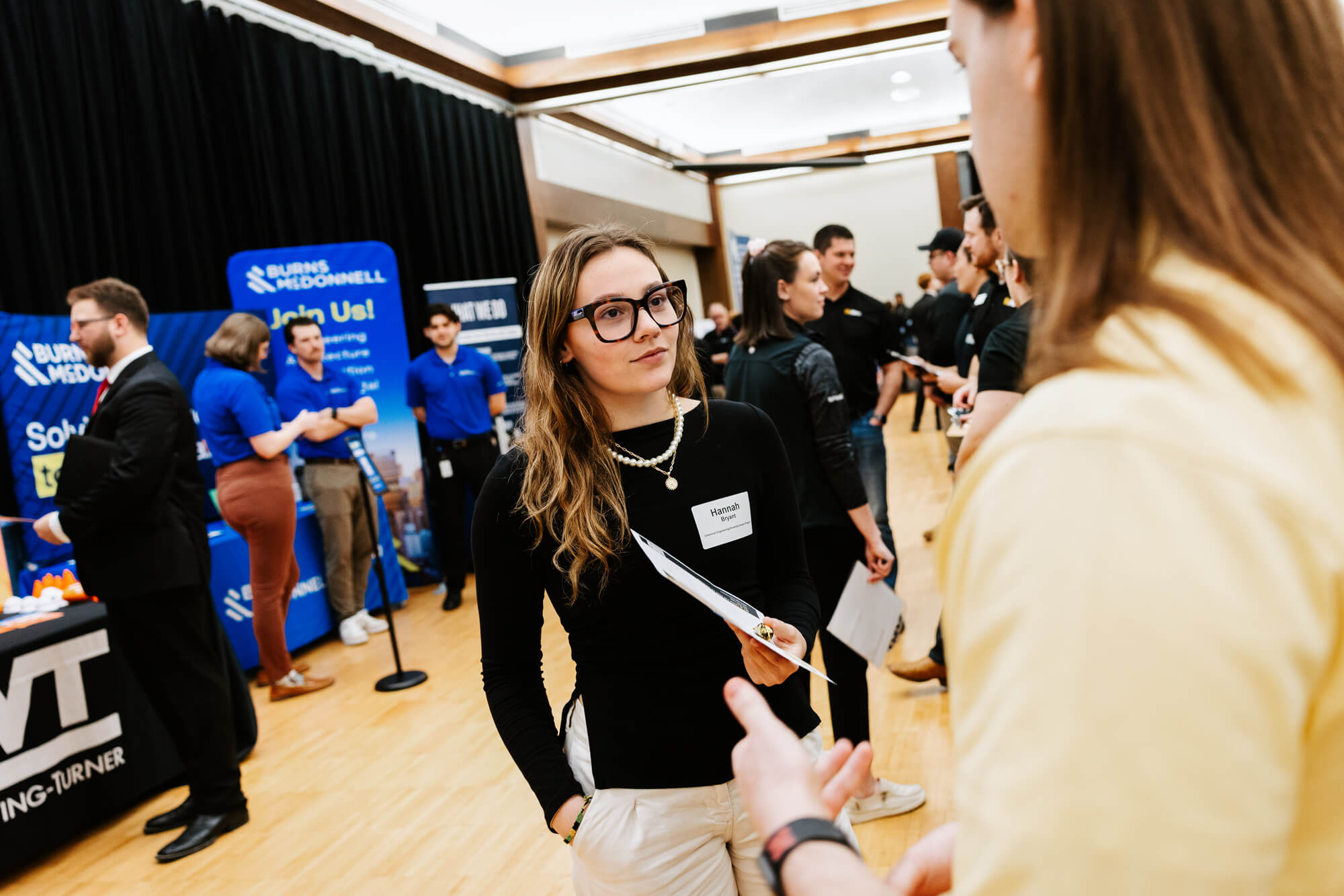 Hannah Bryant, a chemical engineering major, speaks with a representative from AGP during a career fair in the Nebraska Union.
