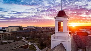 The sun rises over the Love Library cupola.