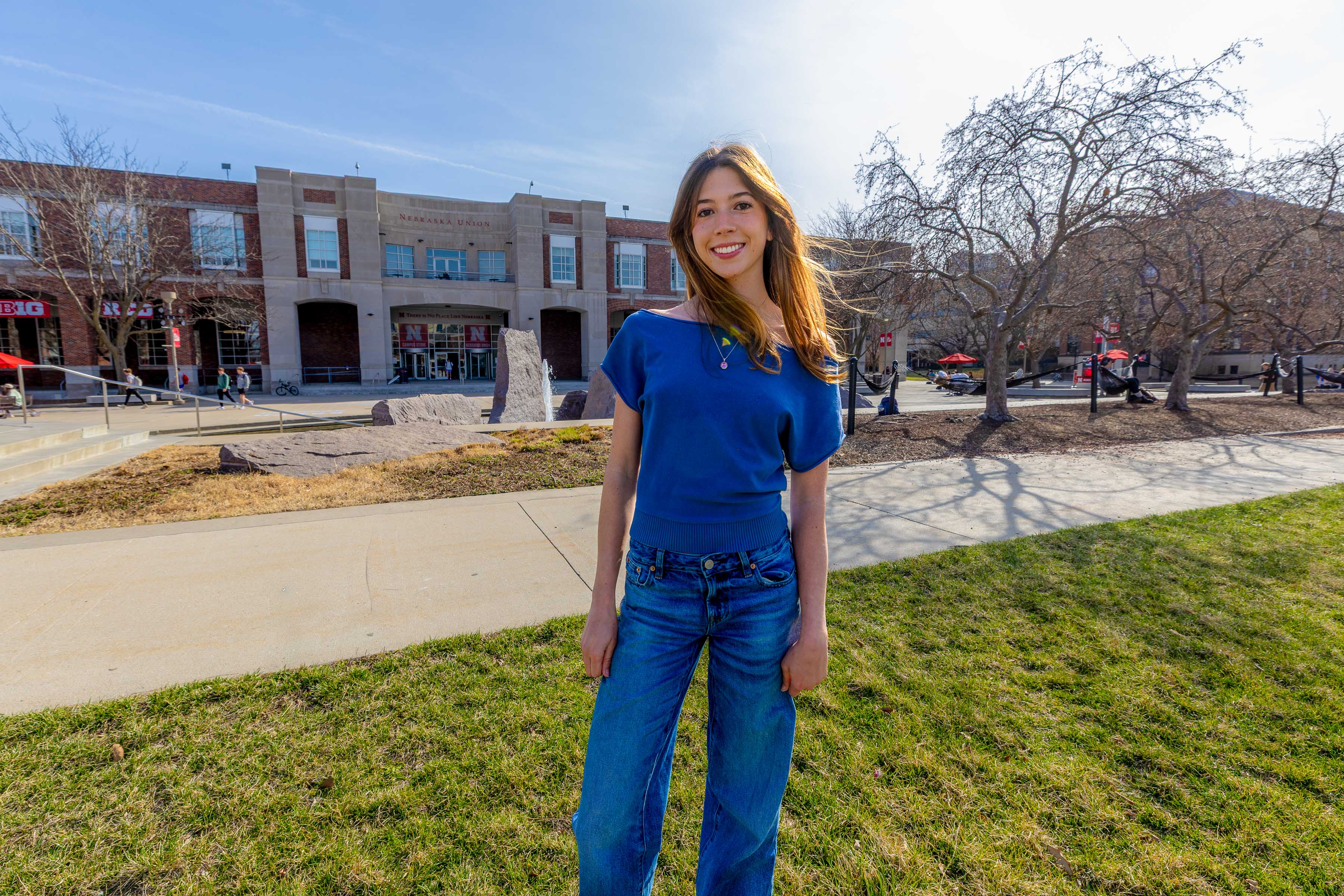 Ashley Mercer poses outside the city campus union wearing a blue shirt and jeans.