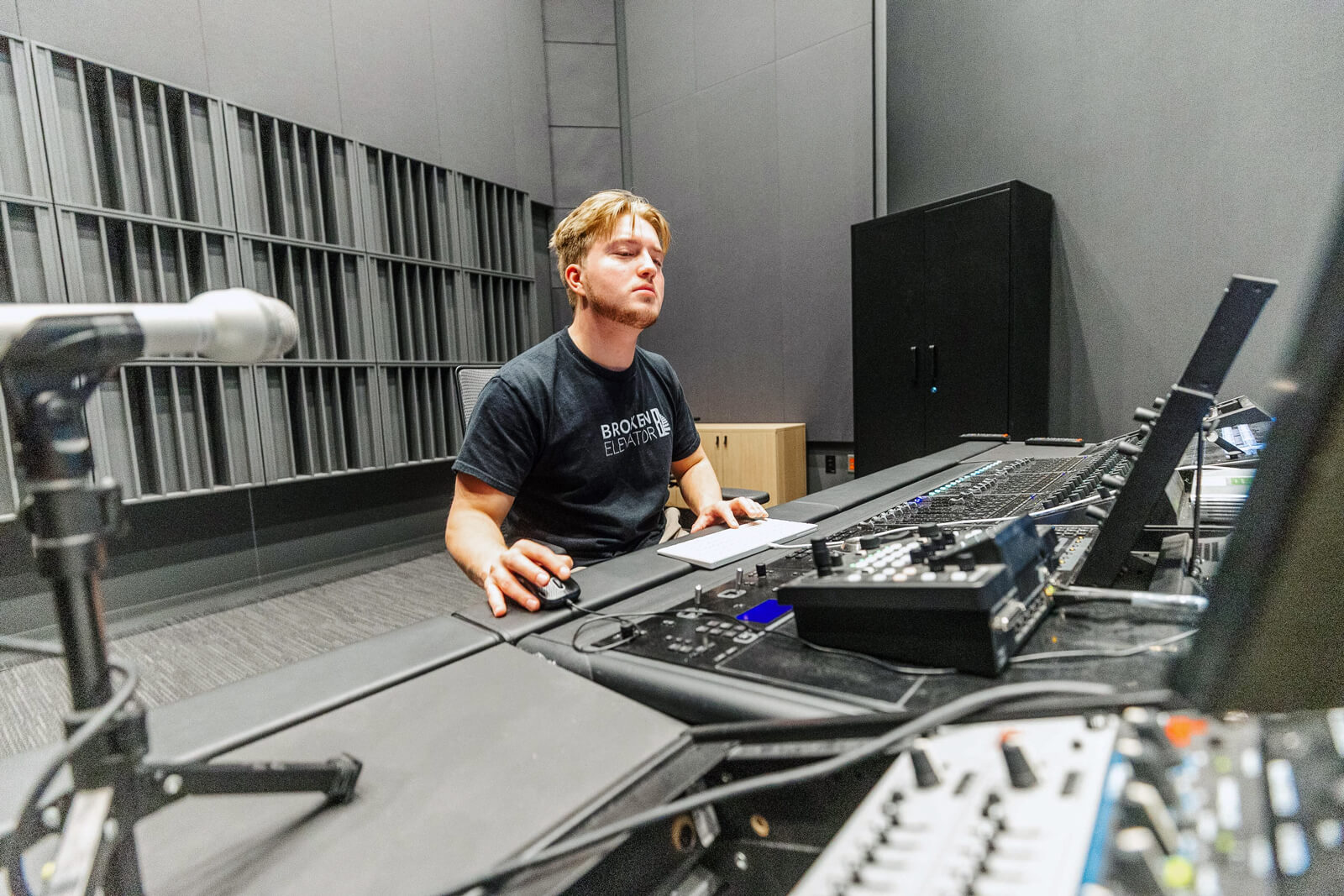 James works at the mixing desk in a recording studio.