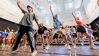 Matt Watson, left, a UNL alum, gives direction to campers during their National Show Choir Camp rehearsal inside Westbrook Music Building.