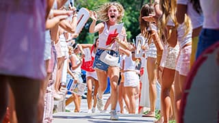 New Delta Gamma members are greeted as they run to their house on Sorority Bid Day.