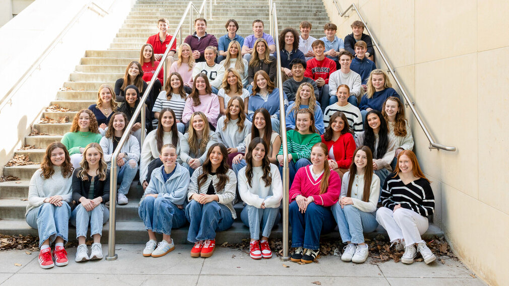 Forty-five students — all new strengths coaches in the University of Nebraska–Lincoln&#039;s Clifton Strengths Institute — sit on an outdoor staircase.
