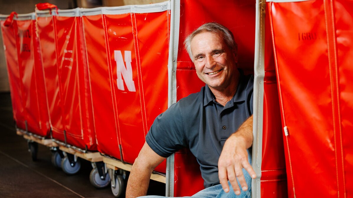 Larry smiles for a photo leaning into the red move-in carts
