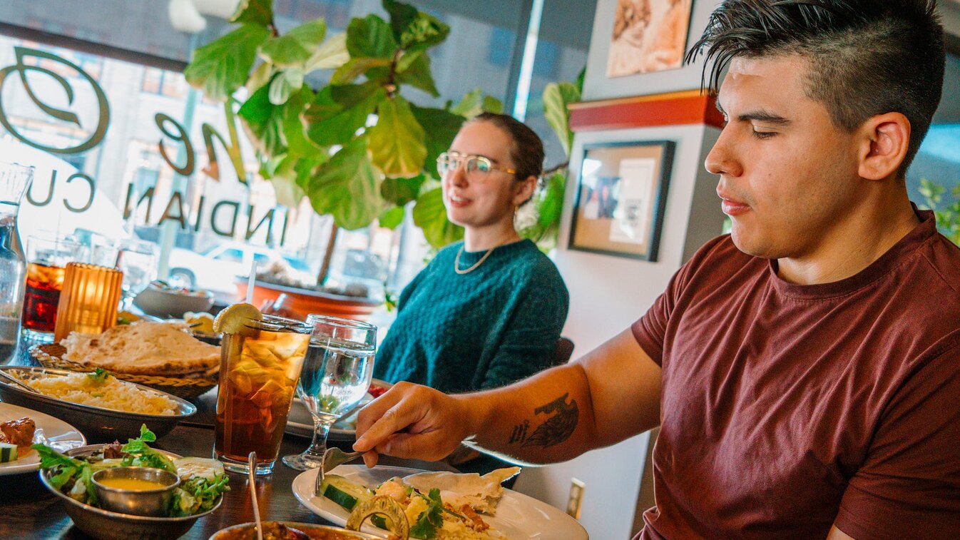 People scoop food from sharable plates at The Oven