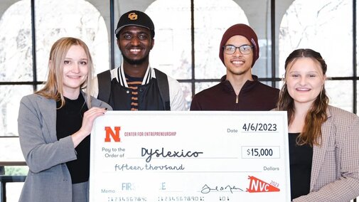 Students hold up a check for their winning pitch during the Center for Entrepreneurship’s annual New Venture Competition.