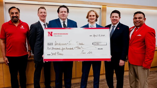 Marcus (third from left) poses for a photo with a check he won from a Center for Sales Excellence competition