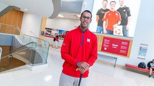 Atirath Deb Roy poses with a golf club in the College of Business' Howard L. Hawks Hall.