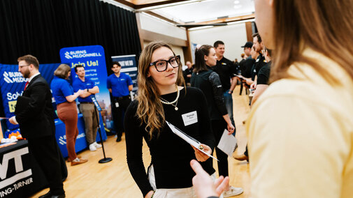 Hannah Bryant, a chemical engineering major, speaks with a representative from AGP during a career fair in the Nebraska Union.
