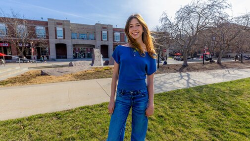 Ashley Mercer poses outside the city campus union wearing a blue shirt and jeans.