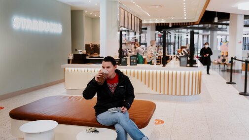 A person drinks coffee at the East Campus Starbucks