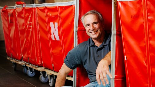 Larry smiles for a photo leaning into the red move-in carts