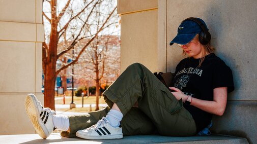 Josephine Browning, a senior Actuarial Science and Statistics and Data Analytics major, enjoying the warm weather in front of the city campus Union.