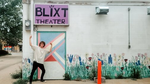 Jaevyn points toward the Blixt Theatre sign