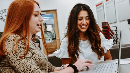 Erika works on a computer in the College of Business