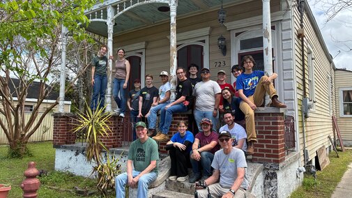 Huskers in Engineers without Borders take a photo on the porch of a house in New Orleans