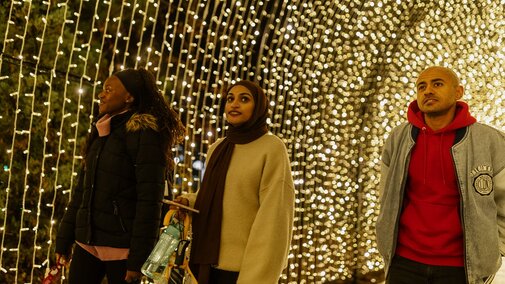 Students walk under a lighted arch at Zoo Lights