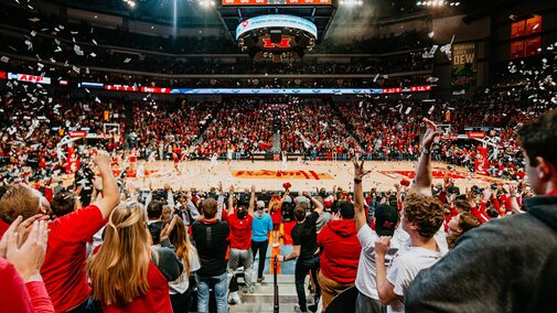 Huskers throw their arms in the air during a past Husker Basketball game