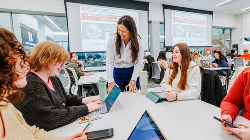 Students chat with their professor in a class in Kiewit Hall on the first day of classes