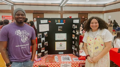 Elena and another NSBE member smile for a photo during the club fair as they tell other Huskers about their organization