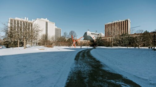 A person walks across campus after a snow