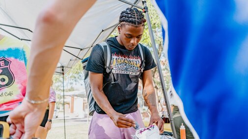 Students tie dye shirts at an event on campus
