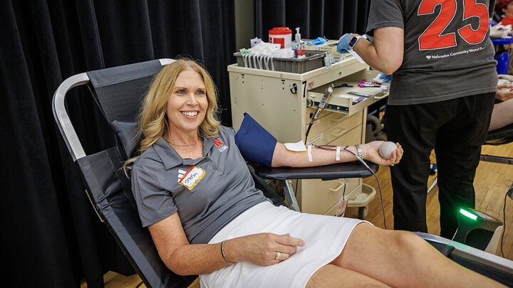 Shelley Zabarowski is seated giving blood in Nebraska Union during Homecoming 2025.