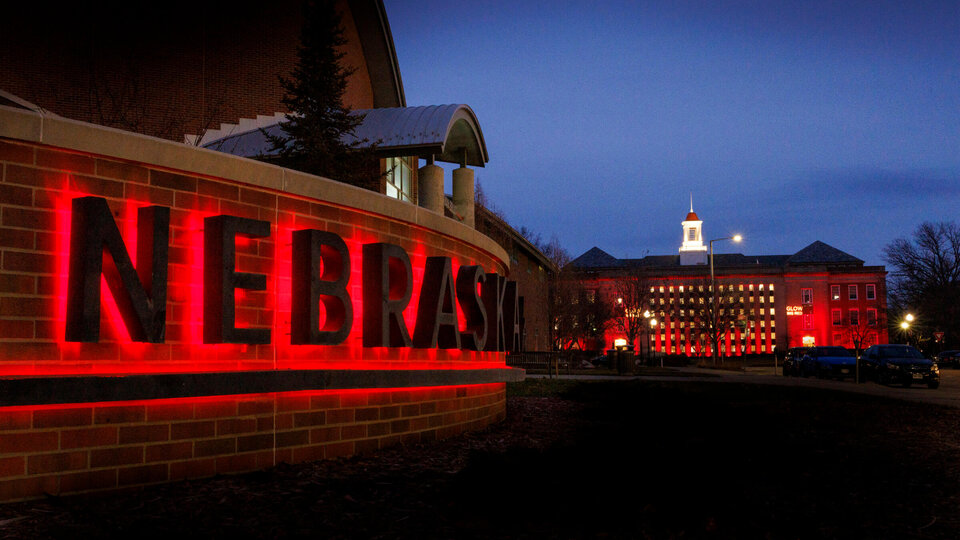 Visitors Center and Love Library lit up with red lights for Glow Big Red Campaign