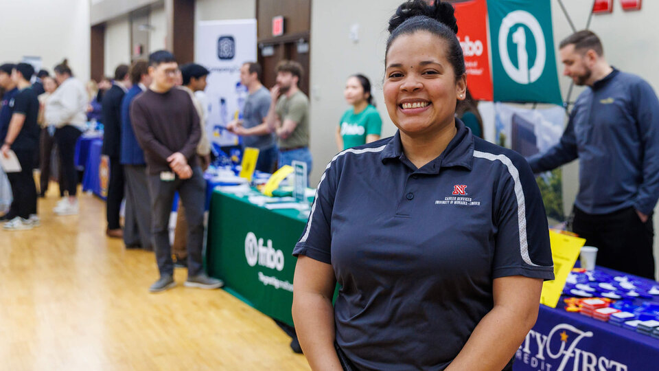 Ronesha Love of Career Services stands in front of tables at Career Fair
