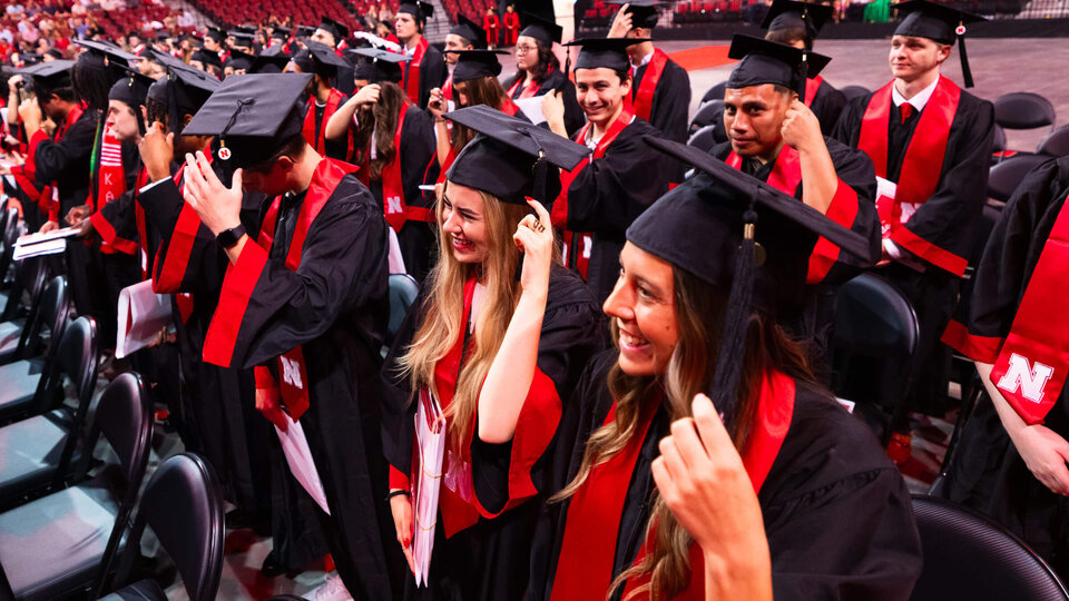 Students flipping tassels during commencement at Pinnacle Bank Arena